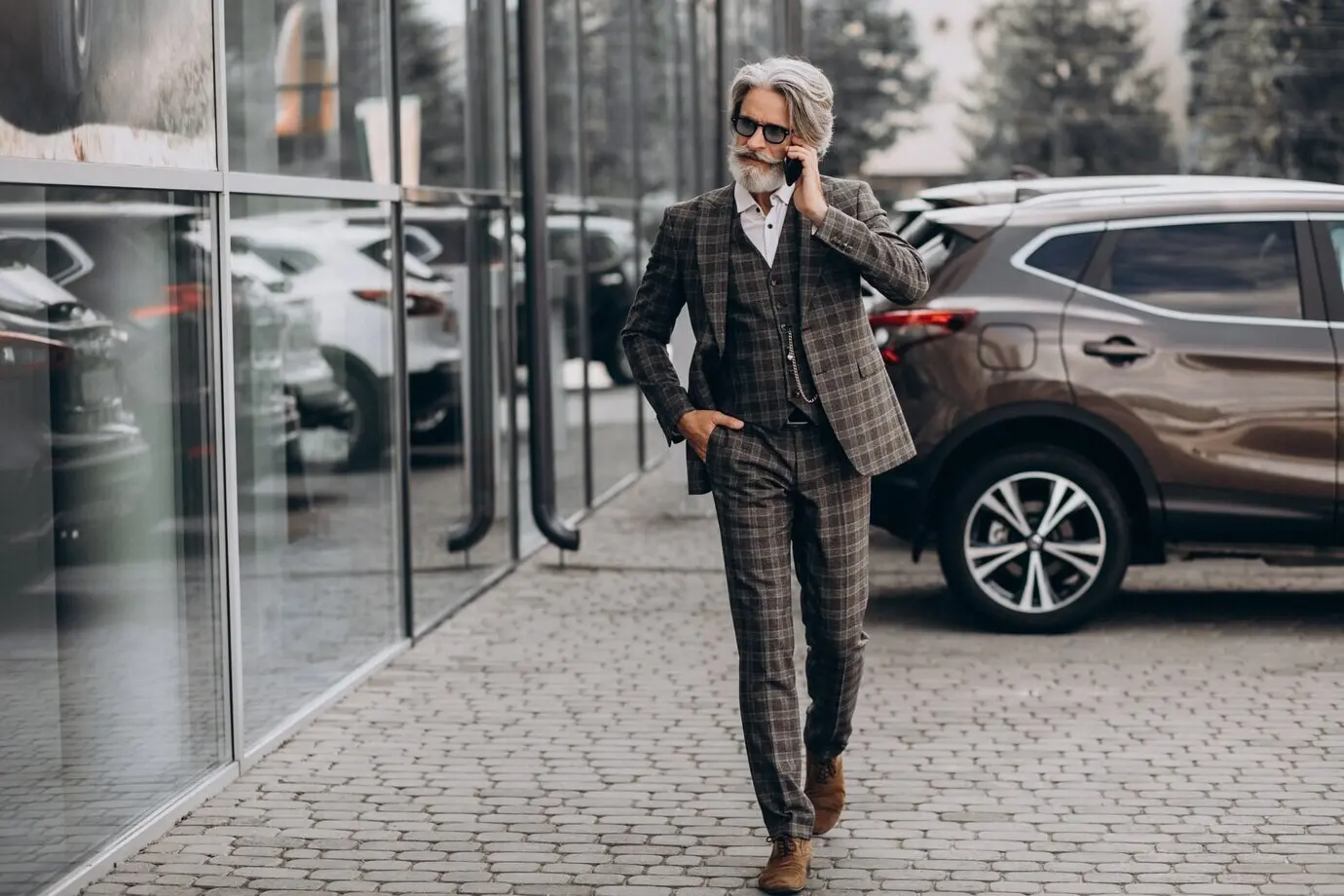 Пожилой бизнесмен разговаривает по телефону.